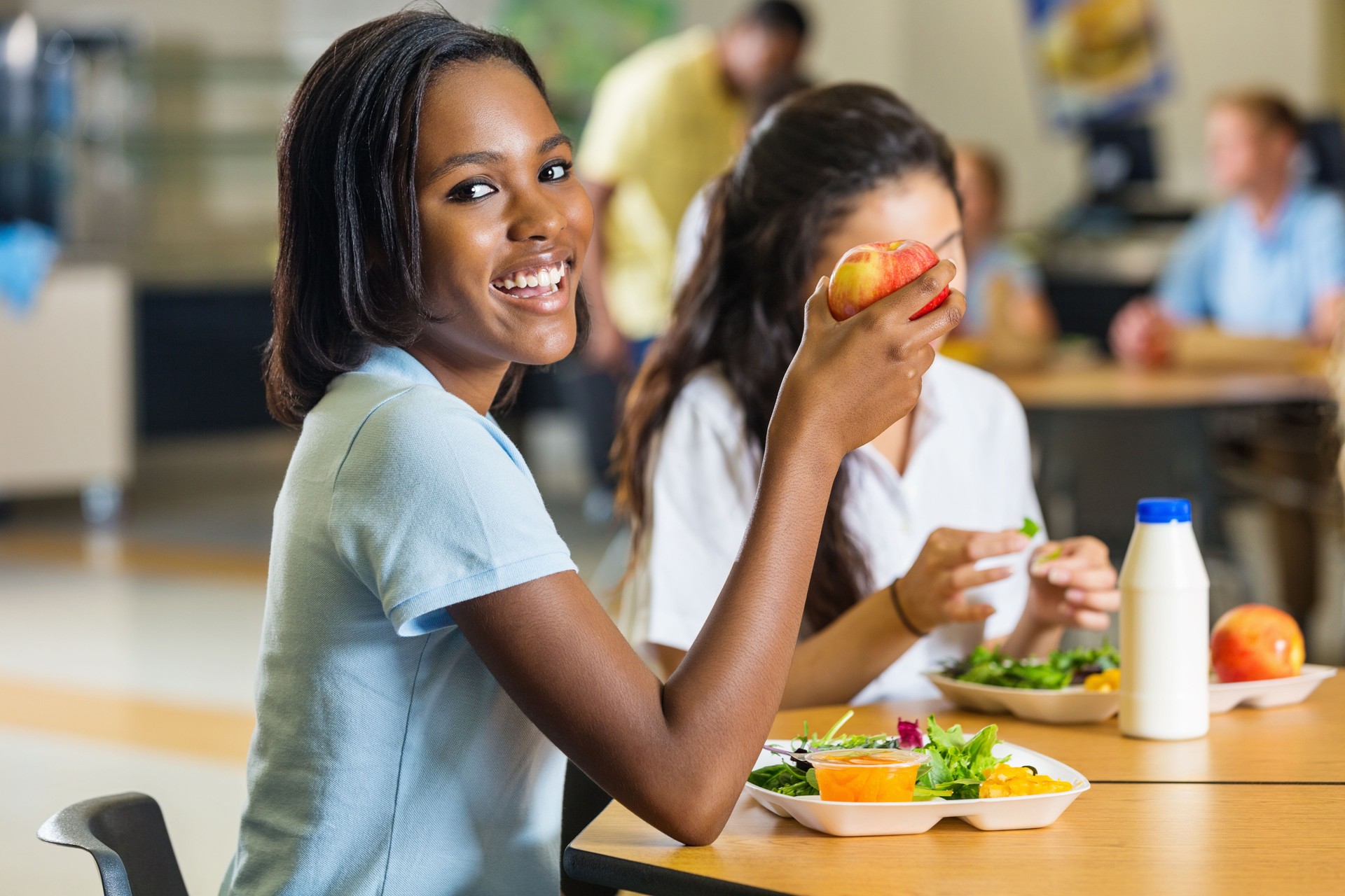 Teen student eating healthy lunch in school cafeteria